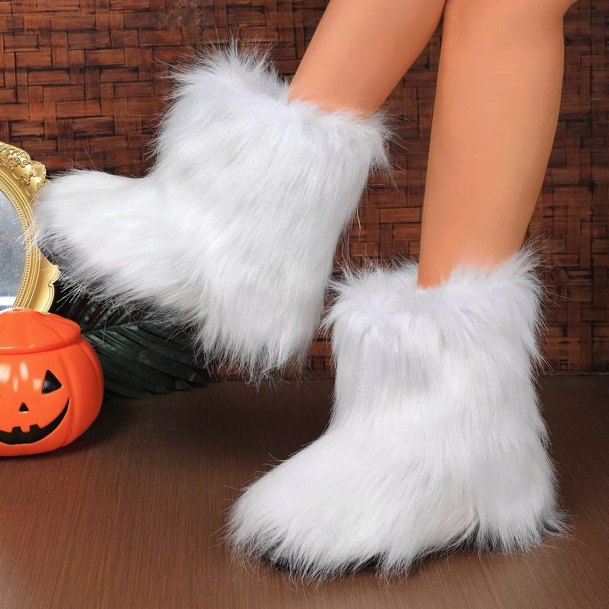 White fluffy boots worn by a person, with a Halloween-themed background featuring a jack-o'-lantern.