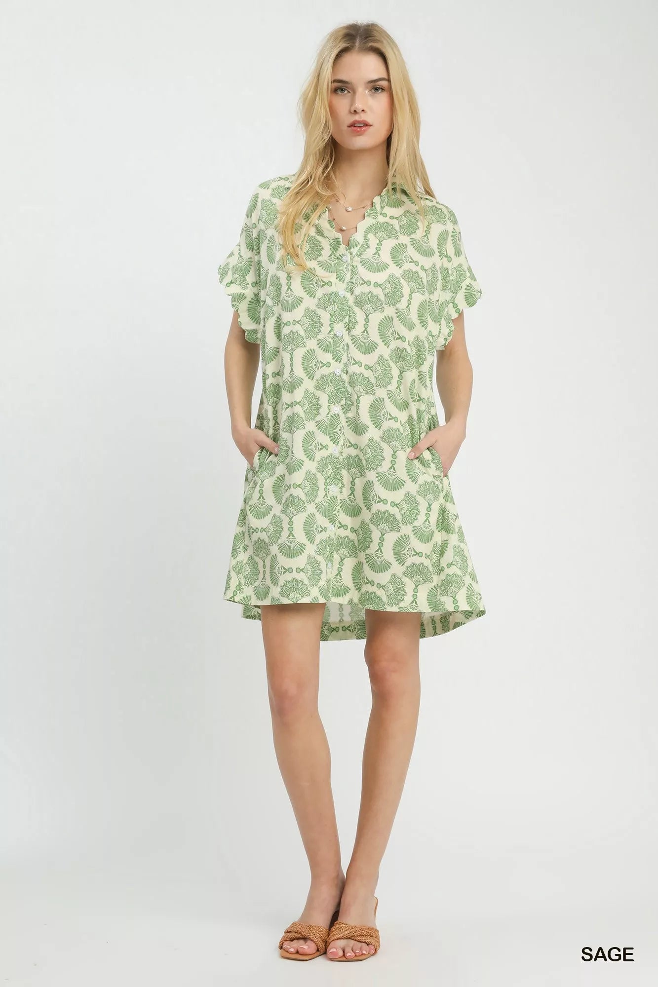 Woman wearing a green patterned dress on a white background