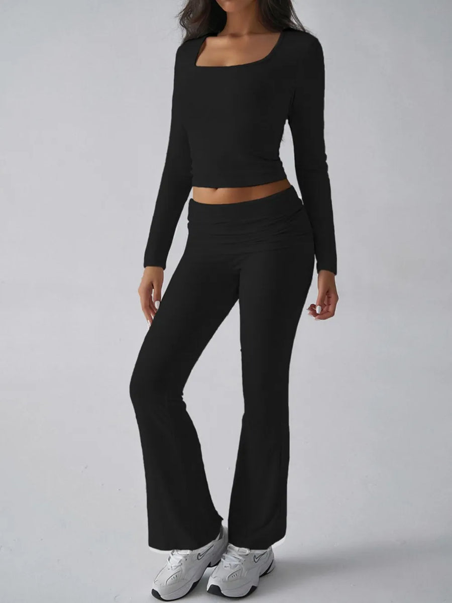 Person wearing a black long-sleeve top and black flared pants on a gray background