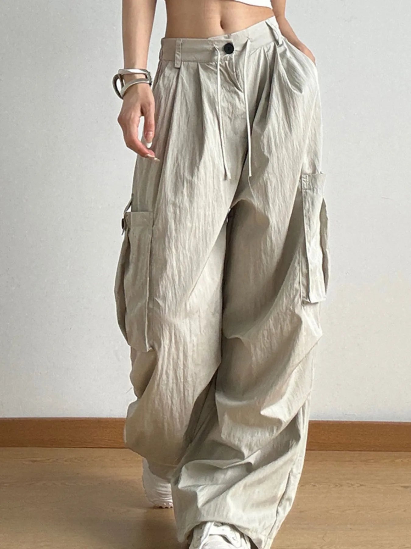 Person wearing beige baggy pants against a plain background