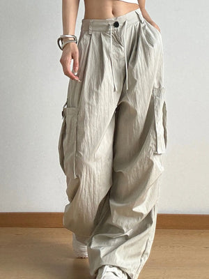 Person wearing beige baggy pants against a plain background