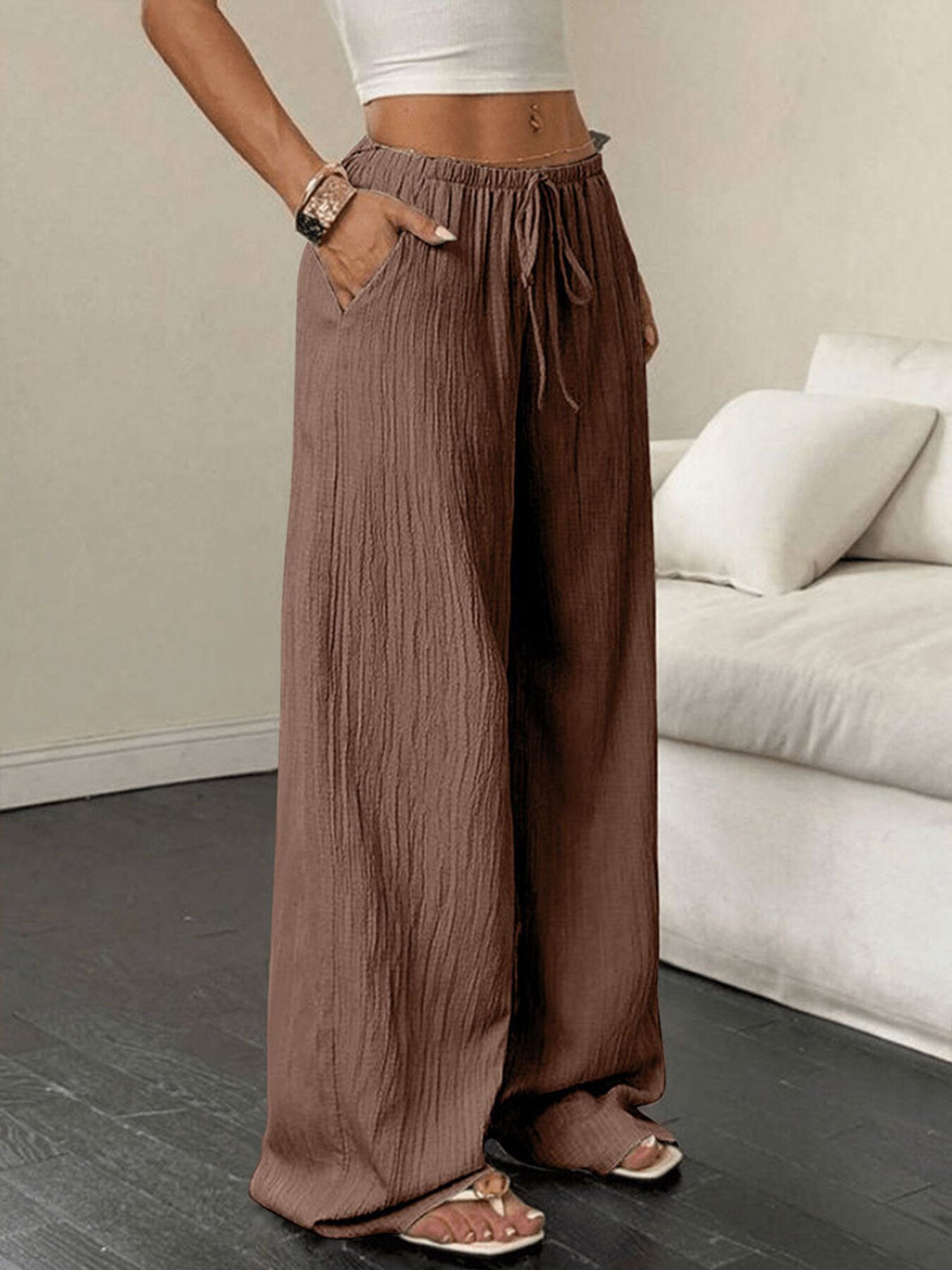 Person wearing brown wide-leg pants in a living room setting