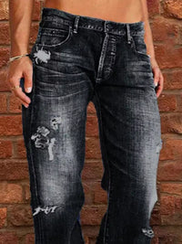 Person wearing distressed black jeans against a brick wall.