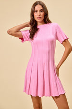 Woman wearing a pink dress against a beige background