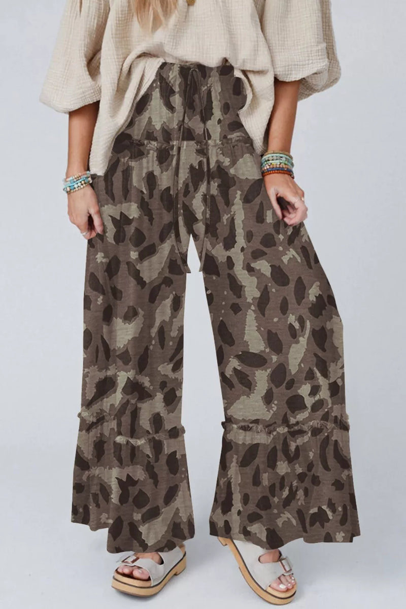 Person wearing leopard print pants on a white background