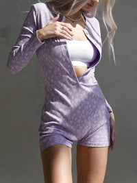 Woman wearing a light purple outfit with a white top against a gray background
