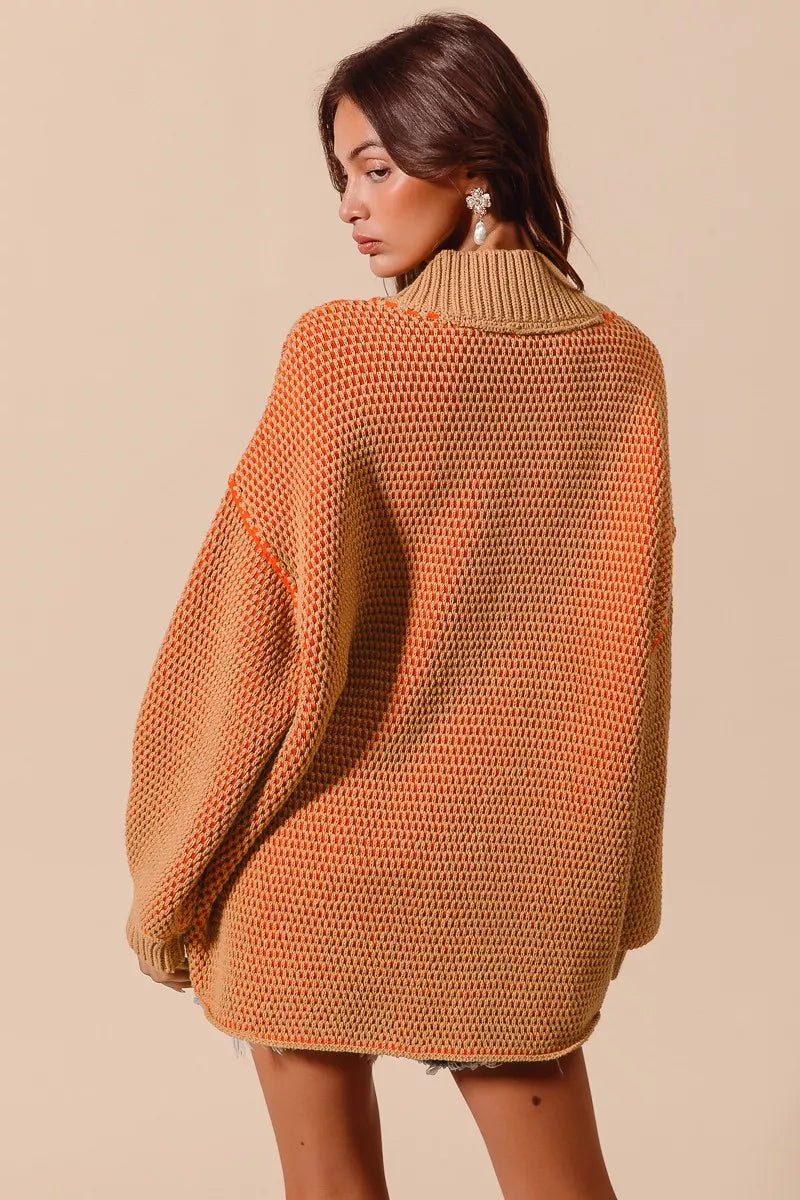 Woman wearing a mustard yellow knitted sweater against a beige background