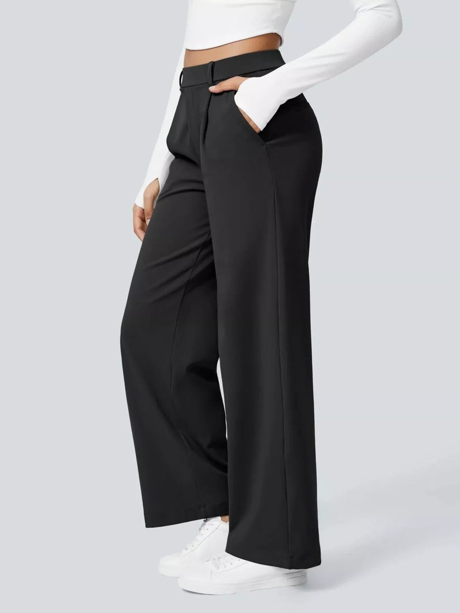 Person wearing black wide-leg pants with a white top on a light gray background