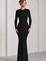 Woman wearing a black long-sleeve gown against a white background