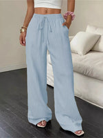 Person wearing light blue wide-leg pants in a living room setting.