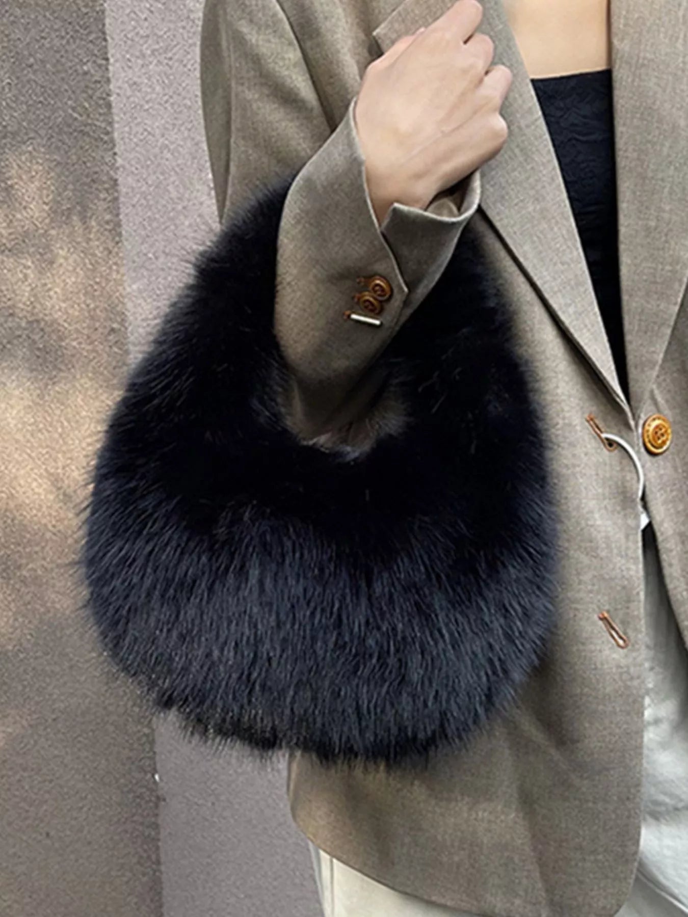 Gray coat with a navy blue fur collar against a neutral background