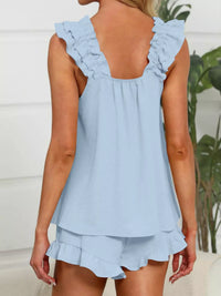 Light blue sleeveless top with ruffled details on a blurred background