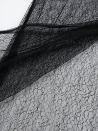 Close-up of black lace fabric on a white background