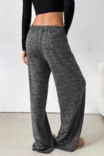 Person wearing gray checkered pants against a white background