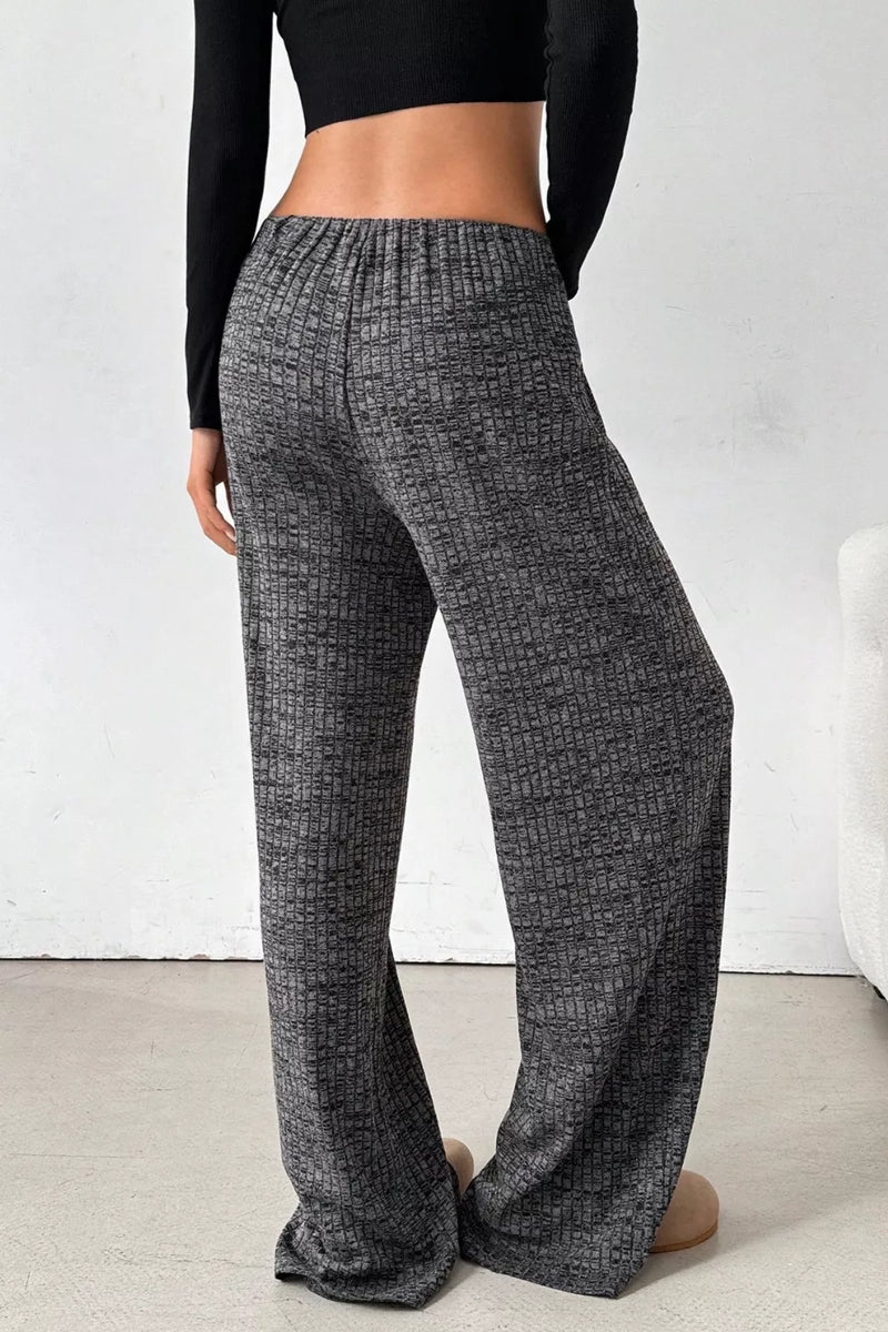 Person wearing gray checkered pants against a white background