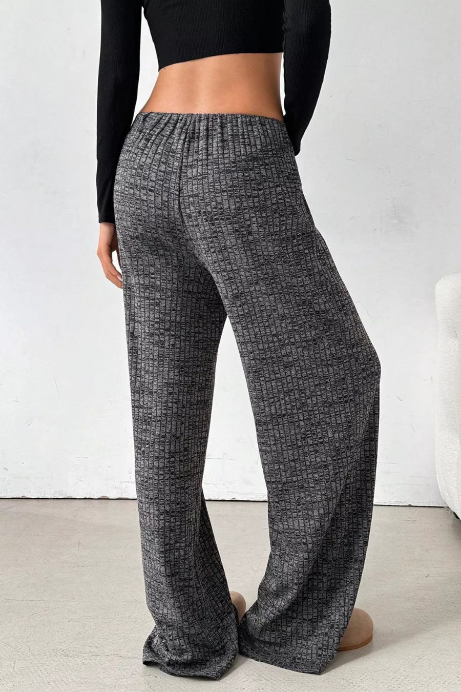 Person wearing gray checkered pants against a white background