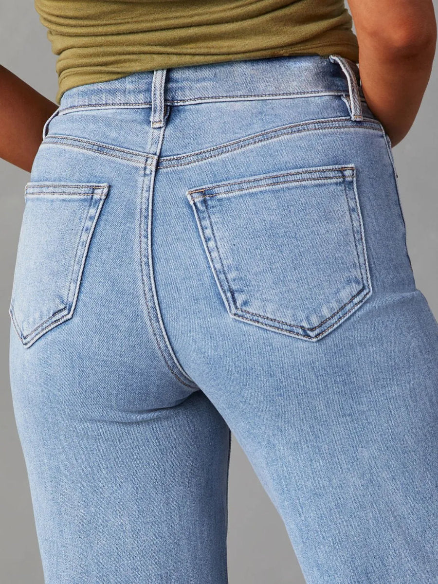 Light blue jeans worn by a person on a gray background