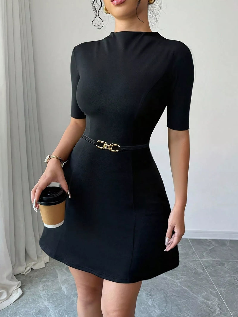 Woman wearing a black dress holding a coffee cup indoors.