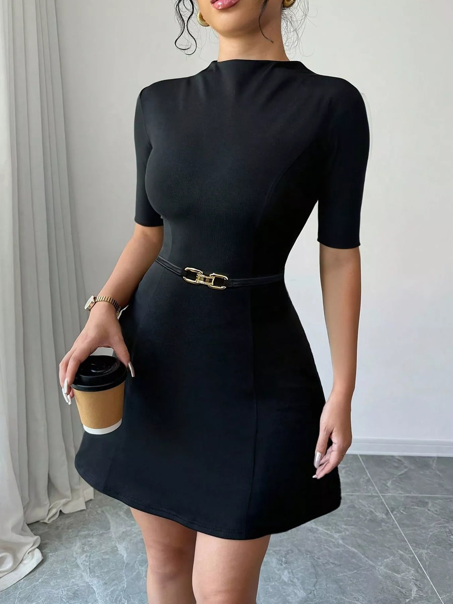 Woman wearing a black dress holding a coffee cup indoors.