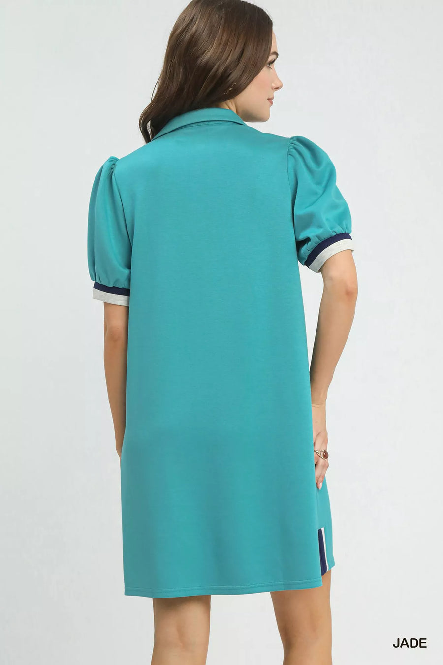 Woman wearing a teal dress with a white background