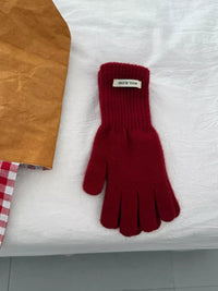 Red glove with a brand label on a white surface