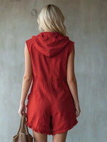 Person wearing a red sleeveless hooded romper against a plain background