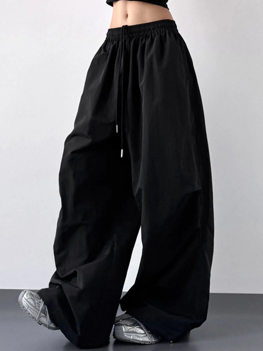 Black wide-leg pants worn by a person on a plain background