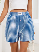 Blue and white checkered shorts with 'Vogue' branding on a white background