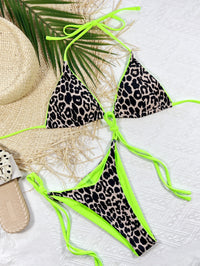 Leopard print bikini with neon green strings on a white background
