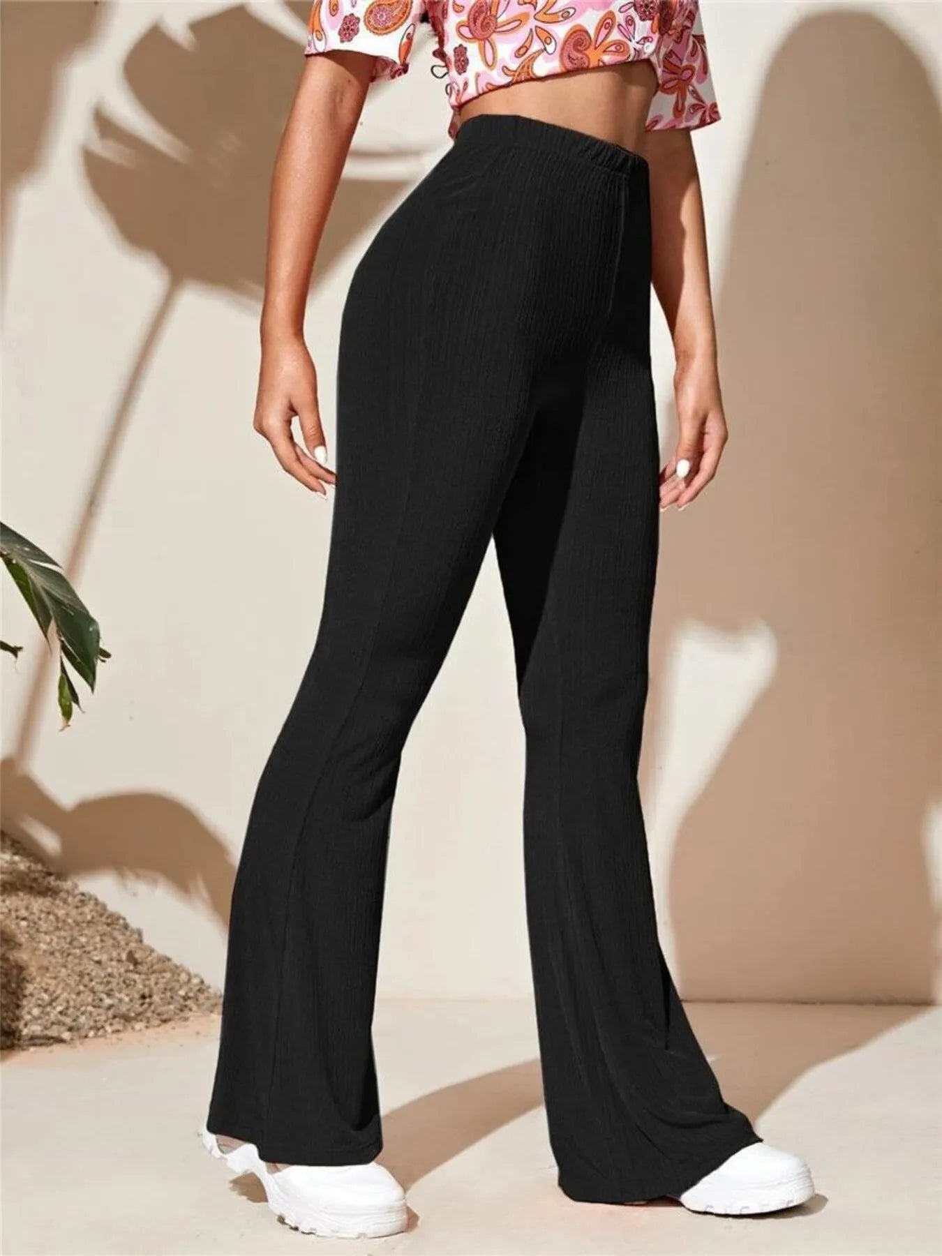 Person wearing black wide-leg pants with a neutral background
