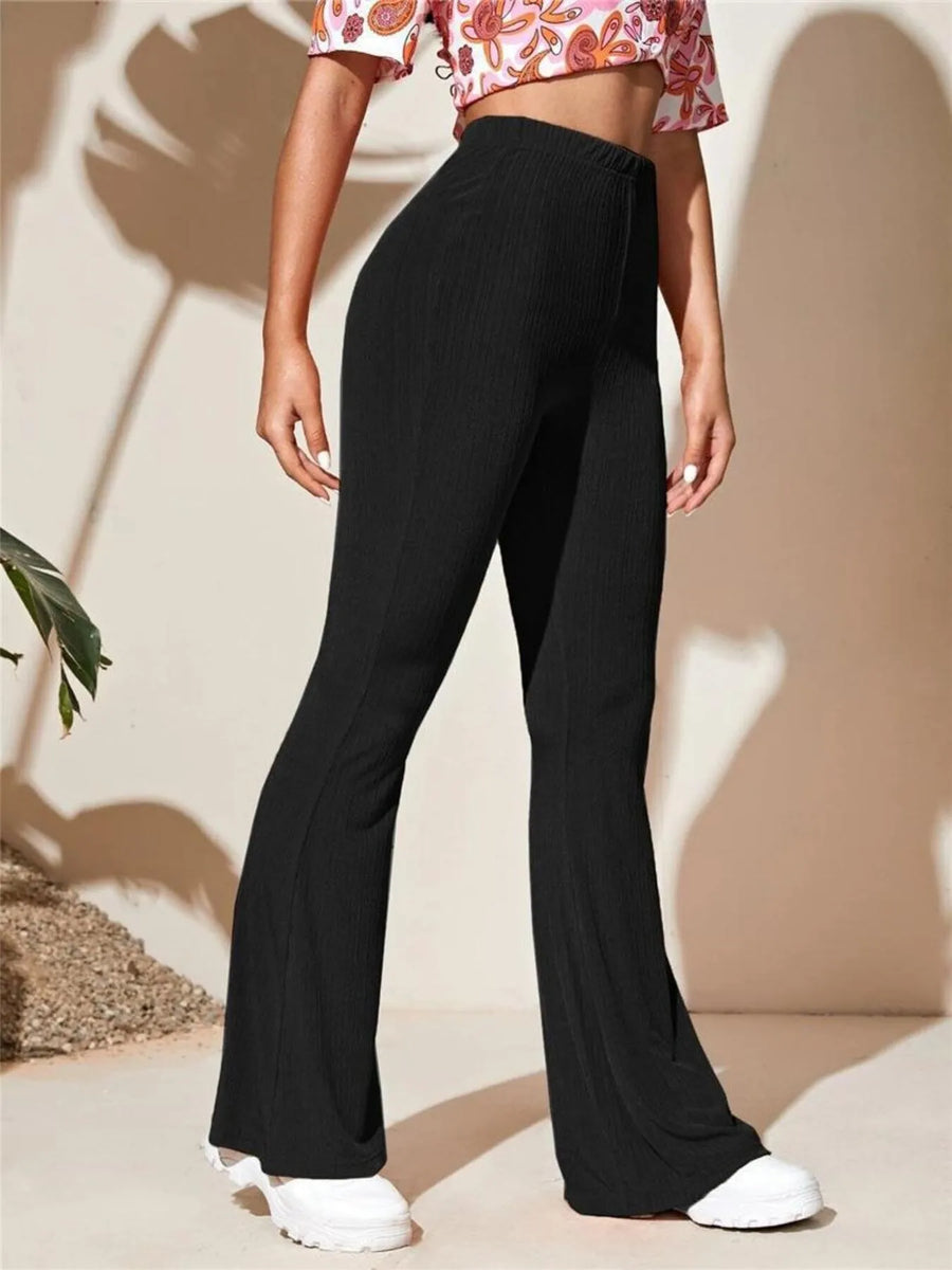 Person wearing black wide-leg pants with a neutral background