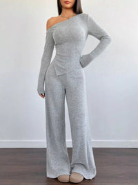 Gray off-shoulder jumpsuit worn by a model on a plain background