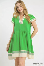 Woman wearing a green dress with white accents on a white background