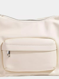 Close-up of a beige handbag with a zipper and pocket on a white background