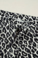 Close-up of leopard print pants with a button and zipper on a light background