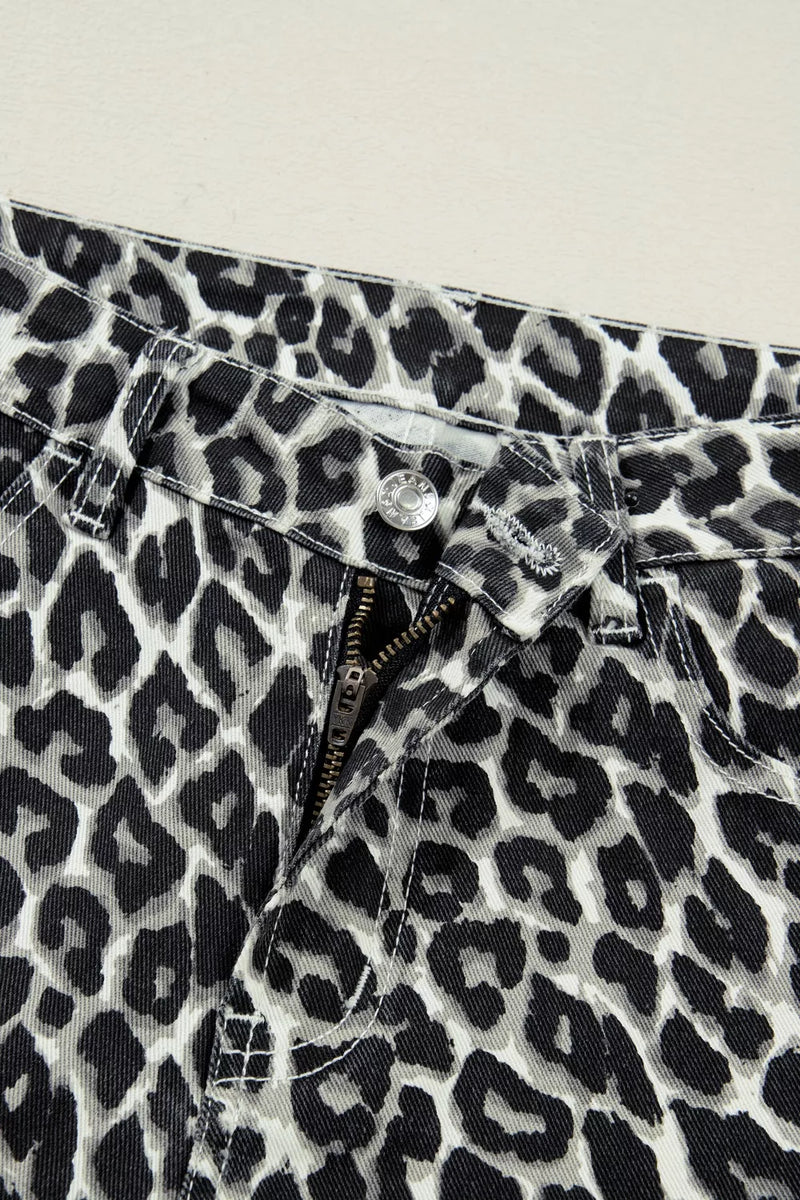 Close-up of leopard print pants with a button and zipper on a light background