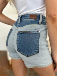 Person wearing light blue denim shorts with a white background