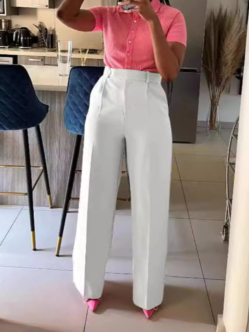 Person wearing a pink shirt and white pants in a kitchen setting
