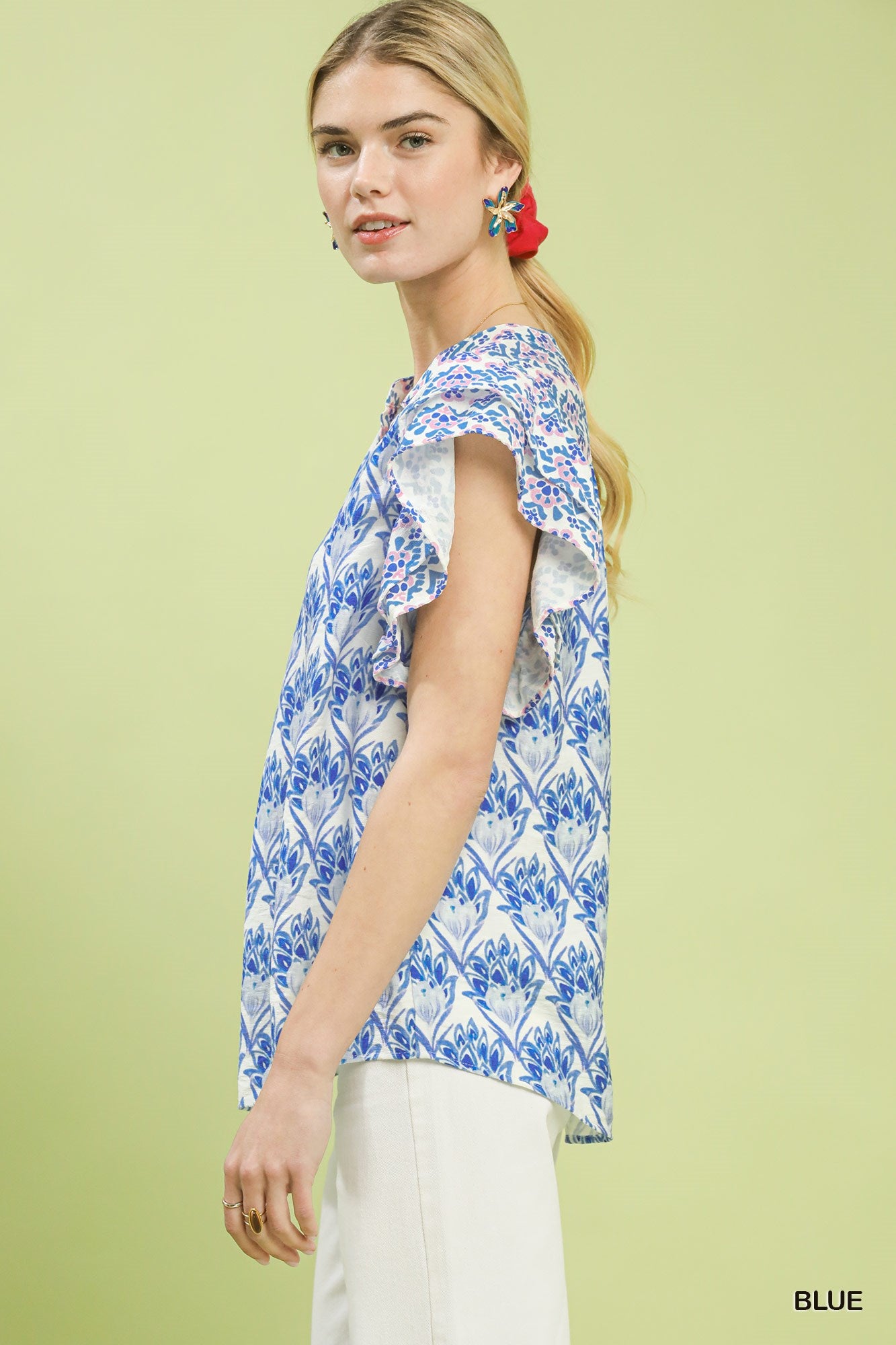 Woman wearing a blue and white patterned top on a light green background