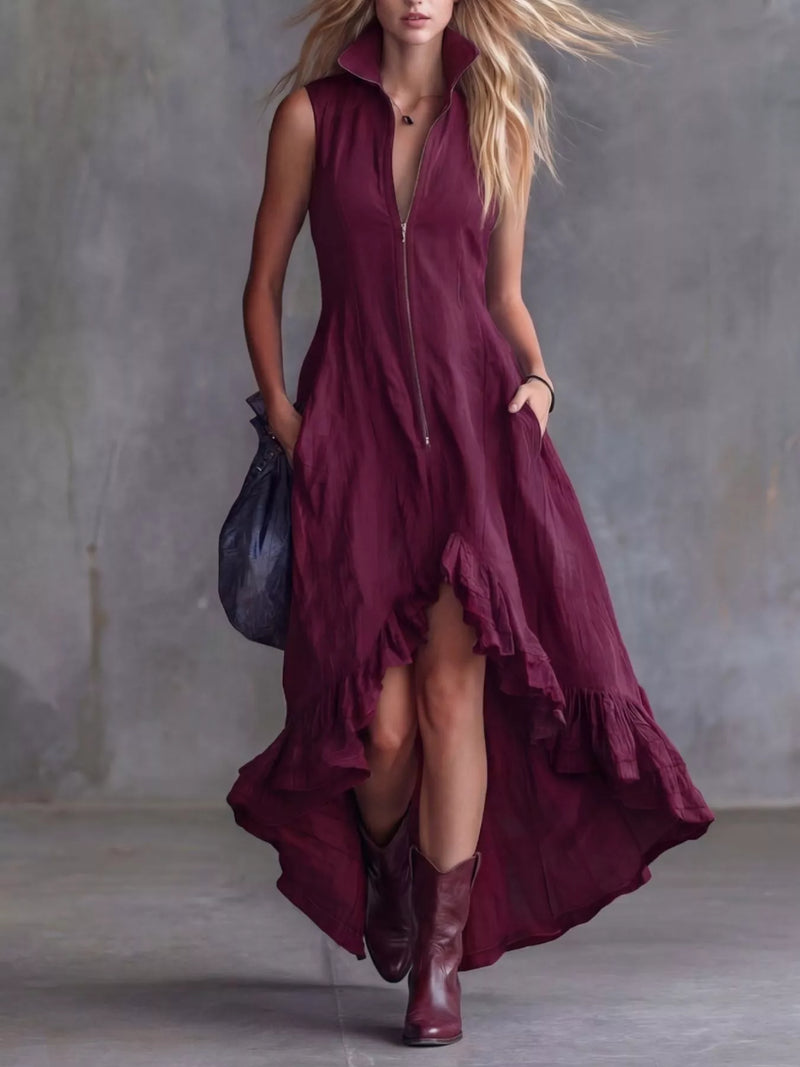 Woman wearing a burgundy dress with a high-low hem and brown boots against a gray background