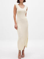 Woman wearing a cream ribbed dress on a white background