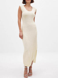 Woman wearing a cream ribbed dress on a white background