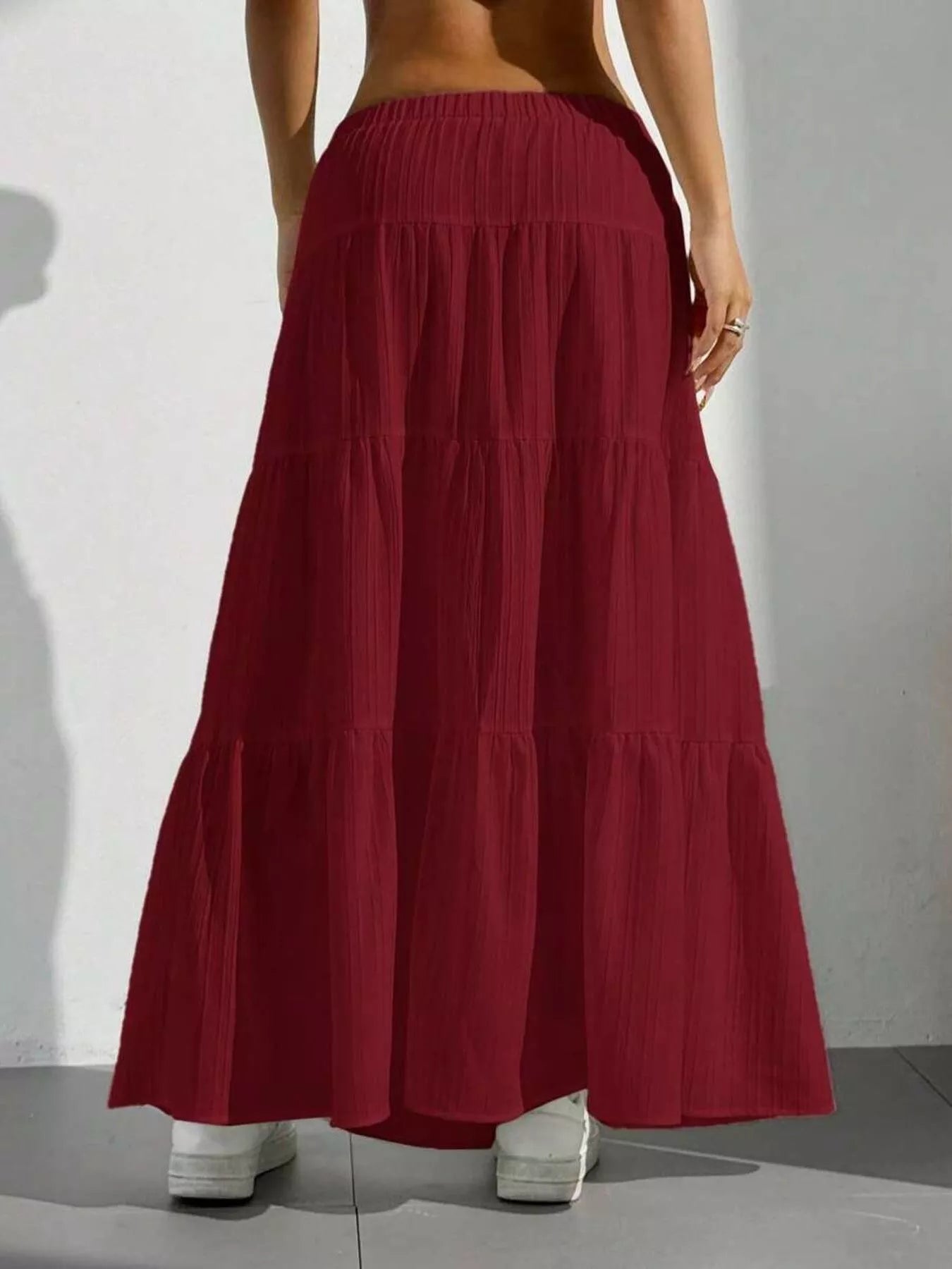 Red tiered skirt worn by a person on a plain background