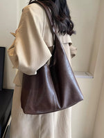 Person wearing a brown leather handbag indoors