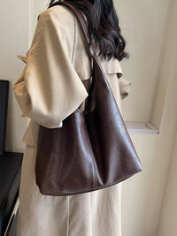 Person wearing a brown leather handbag indoors