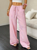 Person wearing pink wide-leg pants in a living room setting