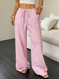Person wearing pink wide-leg pants in a living room setting