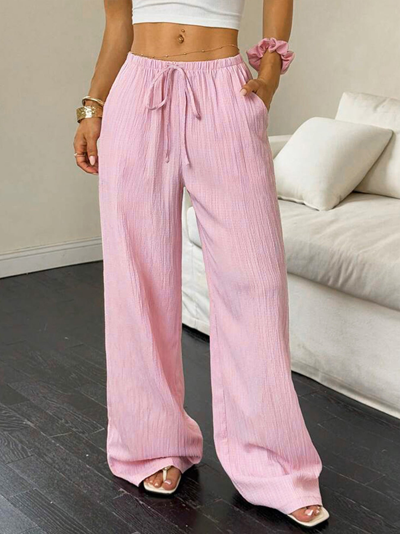 Person wearing pink wide-leg pants in a living room setting