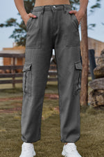 Person wearing gray cargo pants standing outdoors with a blurred background
