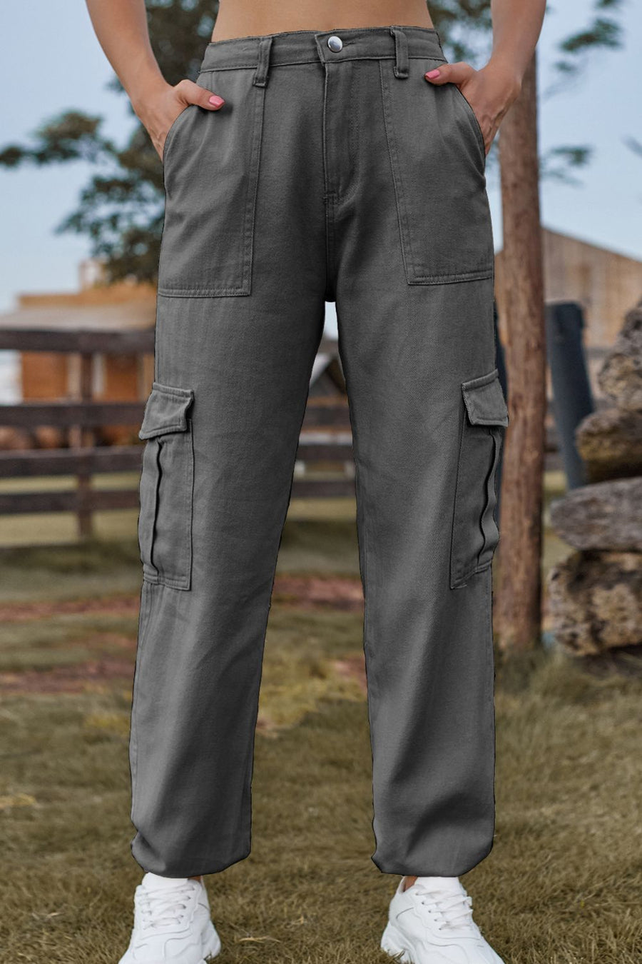 Person wearing gray cargo pants standing outdoors with a blurred background